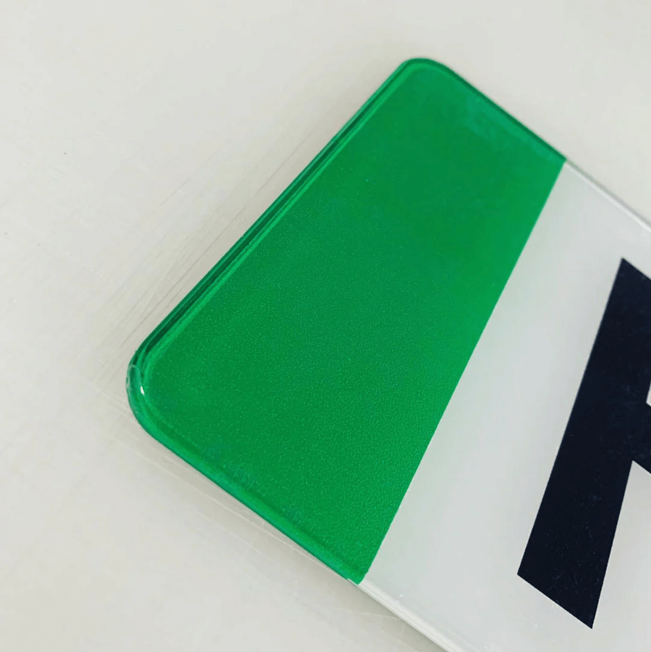 Close-up of green strip on standard oblong 520x111mm acrylic EV number plate, showcasing premium gloss finish.